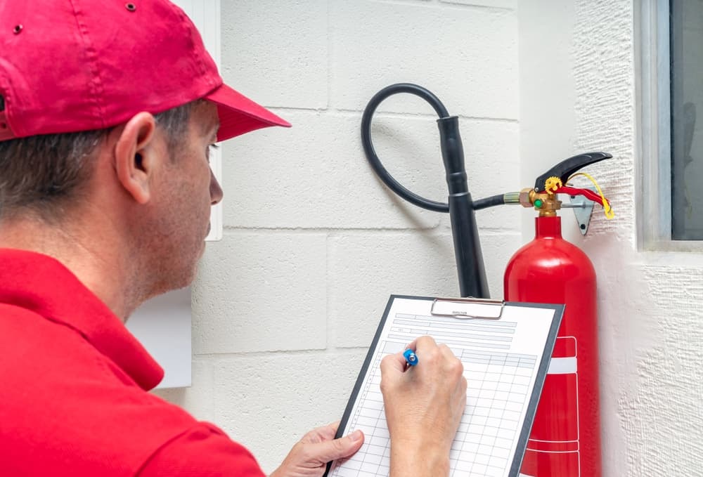 technician inspecting fire extinguisher